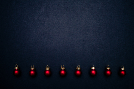 Christmas red shiny balls flat layout on dark background. Top closeup view with copy space.の写真素材