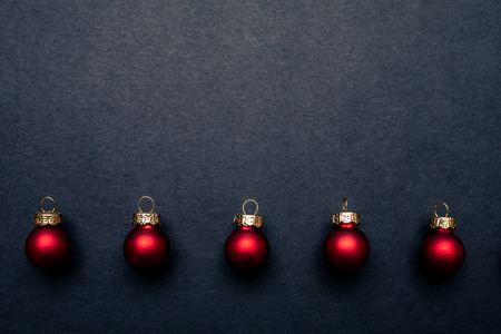 Christmas red shiny balls flat layout on dark background. Top closeup view with copy space.の写真素材
