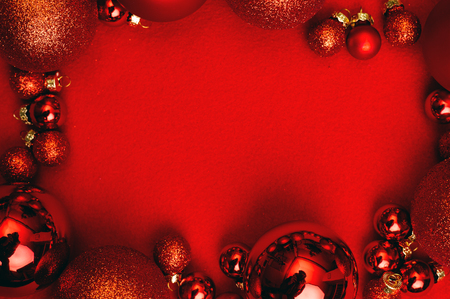 Christmas red background with fir tree, red Christmas balls frame. Top flat view with copy space.の写真素材