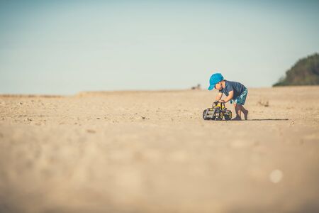 Toddler boy playing with toys on a sunny beach. Little child walking on sand. Beautiful inspirational beach and ocean view, landscape.の写真素材