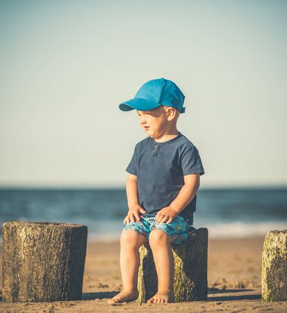 Toddler boy walking on a sunny beach. Little child walking on sand. Beautiful inspirational beach and ocean view, landscape.の写真素材