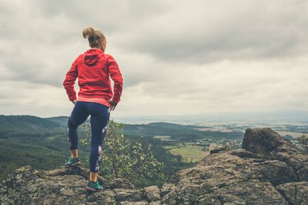Hiking girl in mountains, looking at view. Travel and healthy lifestyle outdoors in fall season. Looking at mountain landscape.の写真素材