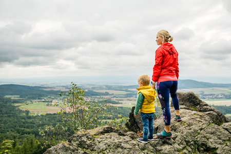 Mother with little boy traveling in mountains. Hiking adventure with child on family trip. Vacations journey with a kid, looking at view.の写真素材