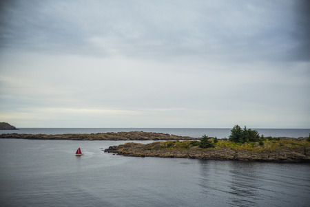Boat with red sail on a calm sea, Norwayの写真素材