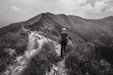 slovakia, Mala Fatra mountains, hiker in red t-shirt walks in mountains towards photographer