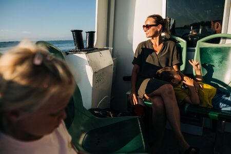 Woman in brown with little son who is playing with shadowの写真素材