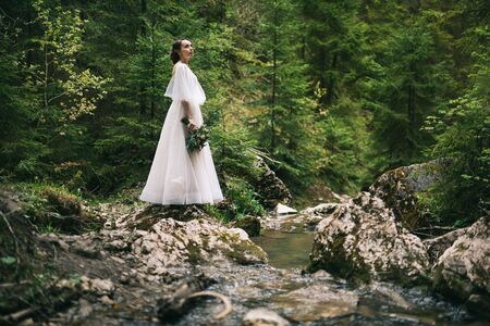 beautiful bride in white dress posing in natureの写真素材