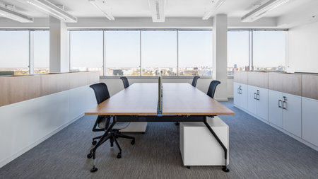 detail of work table for four employees with city view, white walls