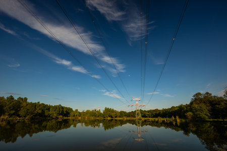 high voltage pylons in a nature reserve, pillars above the waterの写真素材