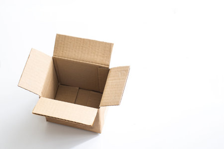 Empty cardboard box isolated against a bright white backdrop