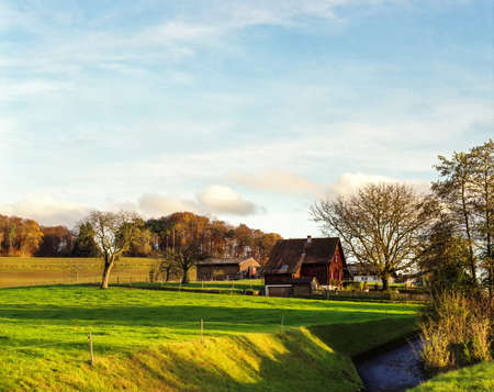 Farmhouse on the hill in autumnの写真素材