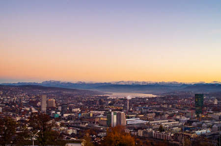 Zurich city vista from atop of Hongg in autumn after sunset before blue hour warm tonesの写真素材