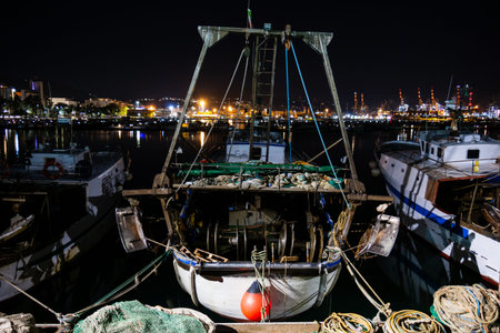 Medium sized fishing boats anchored in in the mediterranean sea port in Italy at night 2019