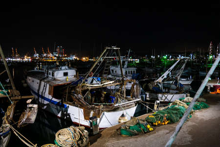 Medium sized fishing boats anchored in in the mediterranean sea port in Italy at night 2019の写真素材