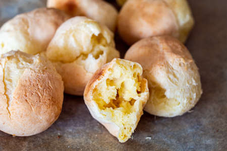 Pao di queijo small cheese breads fresh out of the oven front piece opened up shallow depth of field warm light 2020の写真素材