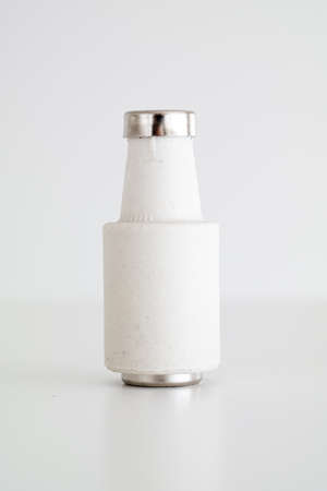 White ceramic electrical fuse cartridge with metal tip close up macro shot isolated on whiteの写真素材