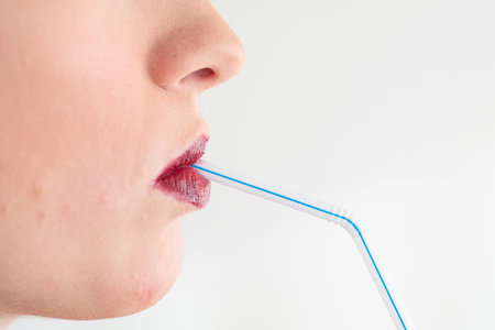 Caucasian sipping from a blue straw close up shot unrecognizable isolated on white 2020