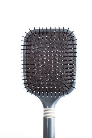 Grey well-used hair brush with handle and visible signs of wear dandruff and skin shavings close up shot isolated on white 2020の写真素材