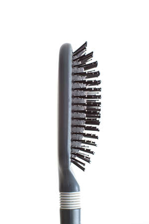 Grey well-used hair brush with handle and visible signs of wear dandruff and skin shavings close up shot isolated on white 2020の写真素材