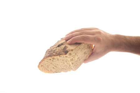 Cut piece of white grain artisan backed bread loaf held by Caucasian male hand close up isolated on pure white 2020の写真素材