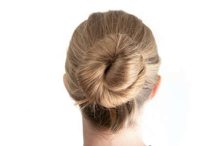 Simple bun hairstyle modeled by young white woman seen from behind close up shot isolated on white 2020の写真素材