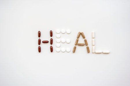 The word heal spelled out from different types of medical pills and capsules set of bright white...
