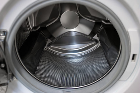 Washing machine open door silver metal empty tumbler close up shot 2020