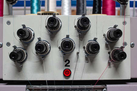 Multi head industrial sewing machine close up view inside small out of business factory warehouse.の写真素材