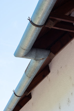 Roof mounted metal rain water draining pipe underside view.