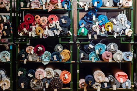 Big rolls of colorful fabric stacked on factory shelves ready for production.の写真素材