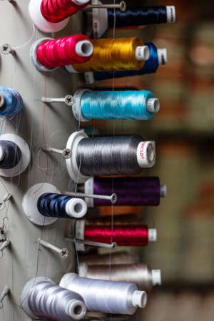 Multi color small spools of sewing thread stacks on large cylinder display.の写真素材