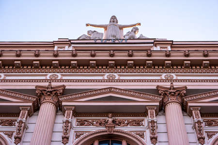Old European renaissance style high school building with angle statue on top low angle point of view.の写真素材