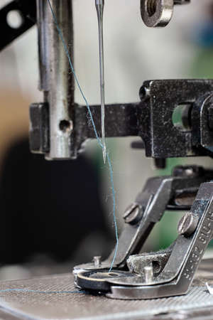 Sewing machine needle with blue thread macro close up shot on the test bench.の写真素材