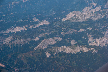 Airplane view of mountain range landscape over Europe cloudy summer day.の写真素材