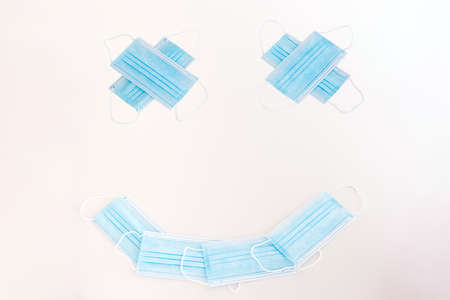 New blue textile medical face masks isolated on white arranged in emoji concept no people to view.の写真素材
