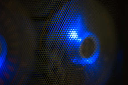 Blue led lighting PC computer cooling fans behind black wire mesh close up shallow depth of field.の写真素材