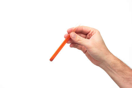 Test tube vial with red liquid held by Caucasian male hand isolated on white background studio shot.の写真素材