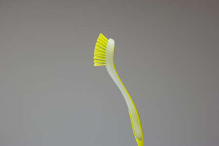 Green rubber plastic kitchen cleaning brush isolated on gray background.の写真素材