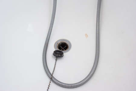 Bathtub rubber plug on a chain next to shower cord close up shot top view.の写真素材