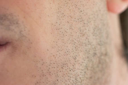 Caucasian male short unshaven facial hair stubble macro close up shot unrecognizable face.の写真素材