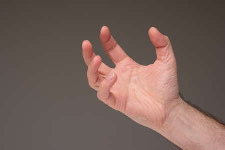Caucasian male hand open palm generic gesture, isolated on brown background. Studio shot.の写真素材
