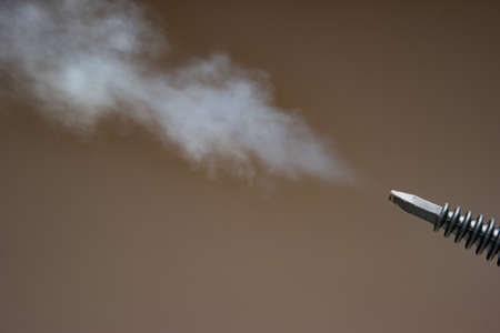 Steam pressure cleaner plastic nozzle spraying water vapor cloud. Close up studio shot, no people.の写真素材