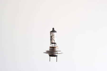 Burned H7 12V 55W halogen car light bulb. Close up studio shot, isolated on white, no people.の写真素材