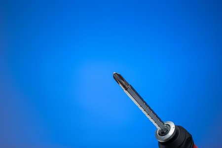 Turn screwdriver macro shot. Close up studio shot, isolated on blue background.の写真素材