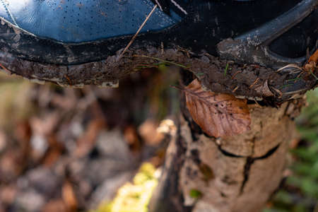 Mud covered hiking boots and sole outdoors. Daytime, no people, close up shot.の写真素材