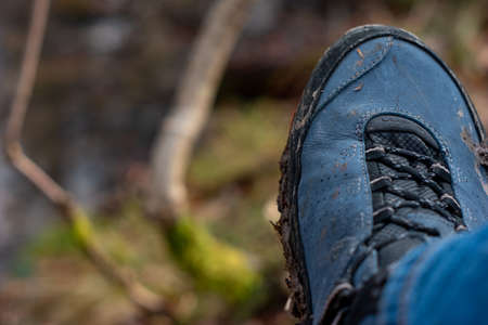 Mud covered hiking boots and sole outdoors. Daytime, no people, close up shot.の写真素材