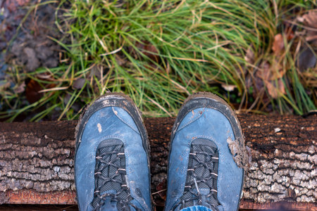 Mud covered hiking boots and sole outdoors. Daytime, no people, close up shot.の写真素材