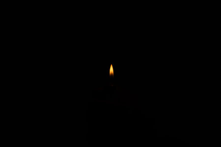 Small lighter flame isolated on dark black background, no people.の写真素材