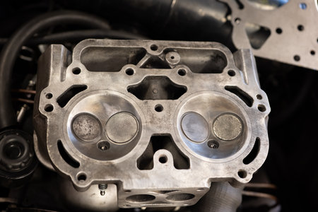 Small V4 boxer engine cylinder head with 2 valves per cylinder. Disassambled for repair, cleaned, and carbon deposit free. No people.の写真素材