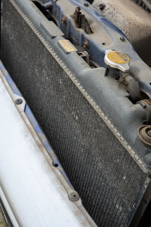 Old rusty car radiator grill with accumulated dirt and small dents. Close up shot, no people.の写真素材